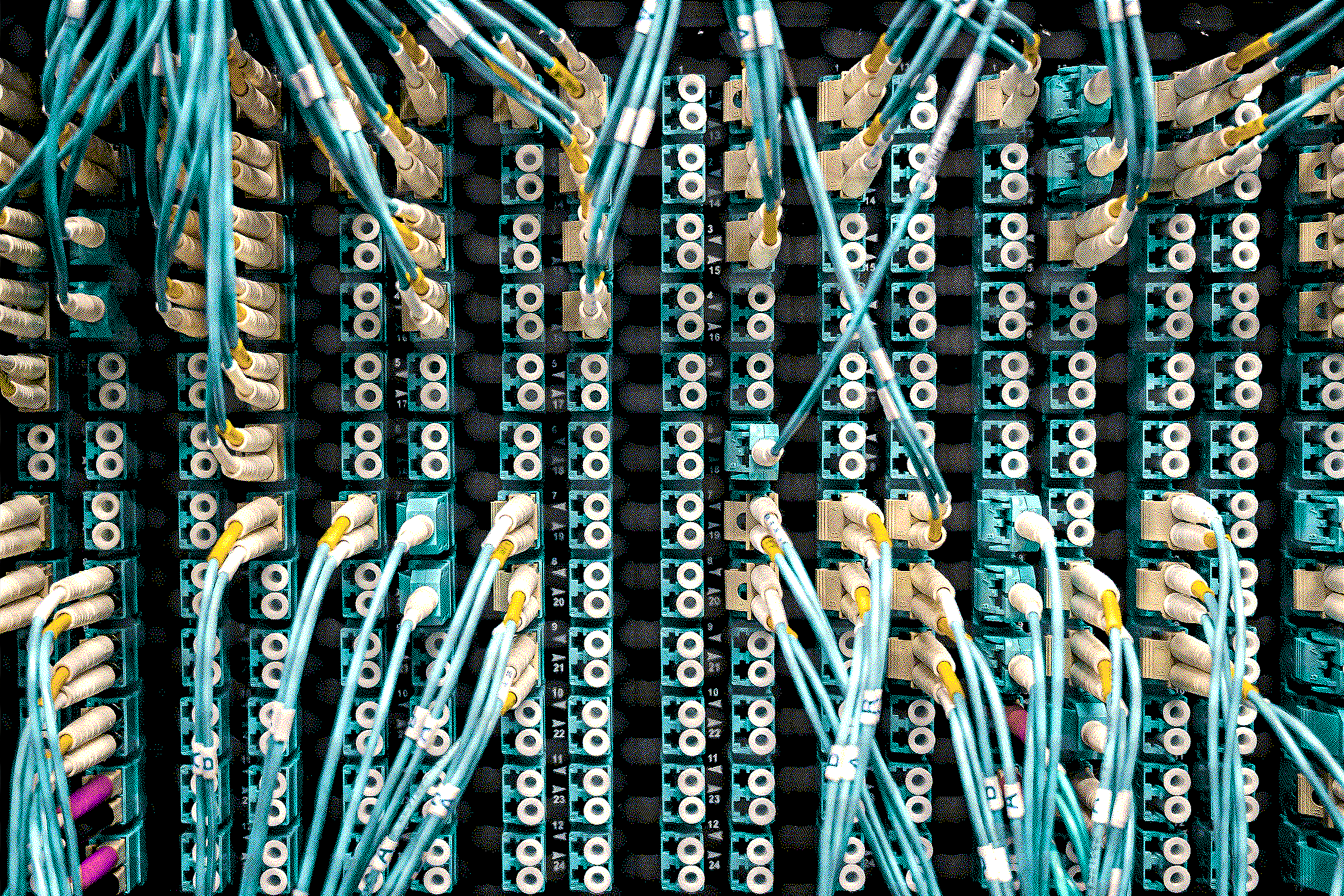 a closeup photo of a server, with many blue, pink, and yellow cables tangling together